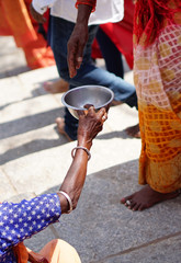Indian devotee give money to poor woman seeking help or begging,near Hindu temple  during maha...