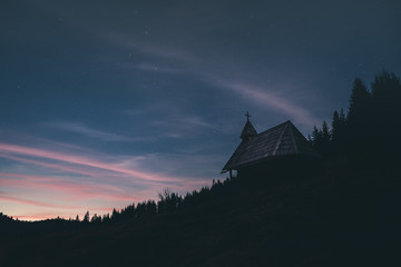 Chapel on the mountain with amazing sunset night sky