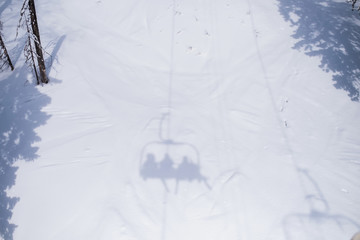 Shadow of the Ski lift on a snowy slope.