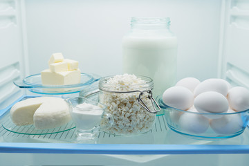 Different milk products with eggs in the fridge.