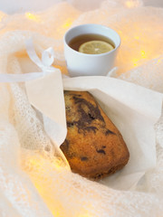 A closeup of a chocolate cake  with a cup of tea