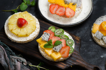 Multigrain rice cakes sandwich with berries, fruit and cream cheese for healthy breakfast.