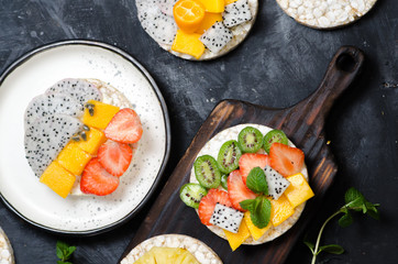 Multigrain rice cakes sandwich with berries, fruit and cream cheese for healthy breakfast.