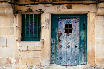 Old green painted door in stone house