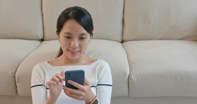 Woman send sms on cellphone at home