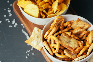 Beer snacks on stone table. Various crackers, potato chips. Top view