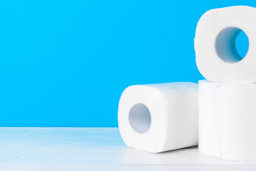 Toilet paper rolls stacked against blue background