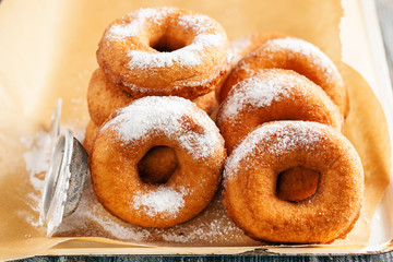 Homemade donuts  with powdered sugar on a wooden baclground