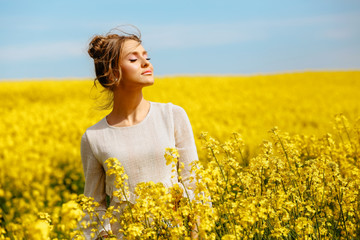 Fototapeta premium Beautiful blonde girl posing in yellow field