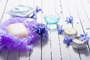skin care product samples and purple hyacinth flowers on white wooden