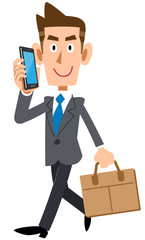 スマートフォンで電話しながら通勤するビジネスマン