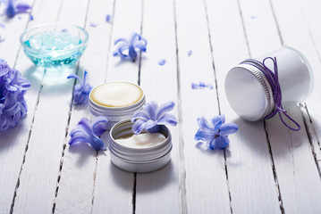skin care product samples and purple hyacinth flowers on white wooden