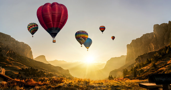 Beautiful panoramic nature landscape of countryside mountains with colorful high hot air balloons festival in summer sky. Vacation travel panorama background.