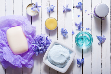 skin care product samples and purple hyacinth flowers on white wooden
