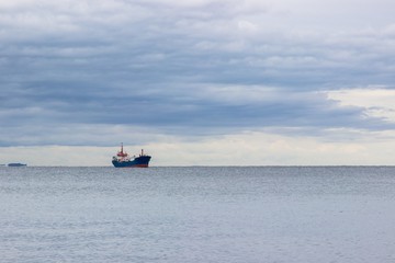 Tranquil seascape with ship at background