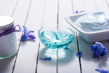 skin care product samples and purple hyacinth flowers on white wooden