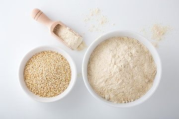 Quinoa flour and quinoa seeds in white bowl