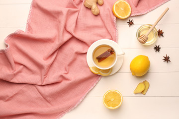 Cup of hot tea with lemon and ginger on white table