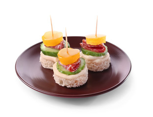 Plate with tasty canapes on white background