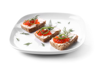 Plate with tasty canapes on white background