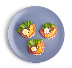 Plate with tasty canapes on white background