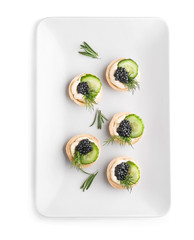 Plate with tasty canapes on white background