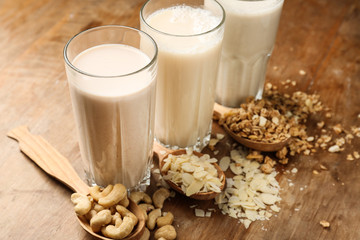 Assortment of tasty vegan milk on wooden table