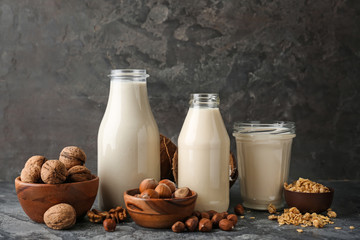 Assortment of tasty vegan milk on grey table