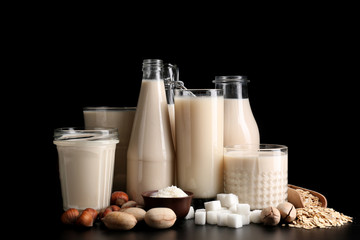 Assortment of tasty vegan milk on dark background