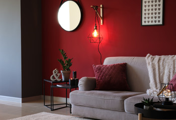 Stylish interior of room with soft sofa and new lamp