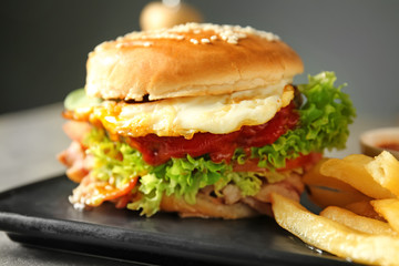 Tasty burger with french fries on plate, closeup