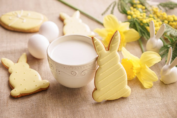 Tasty Easter cookie with milk on table