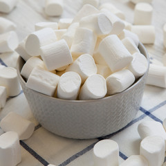 Fototapeta na wymiar Sweet white marshmallows in a bowl, side view. Close-up.