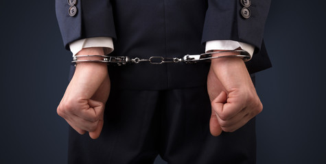 Close now arrested men hand with dark background and handcuffs
