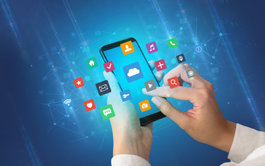 Female hand using smartphone with colorful application icons around