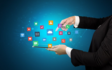 Female hand touching tablet with application icons above