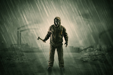 Gas masked survival man coming with arms on his hand  in a demolished dark environment 
