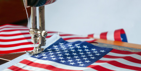 Sewing small american flags. Preparation for celebrating 4 th of july