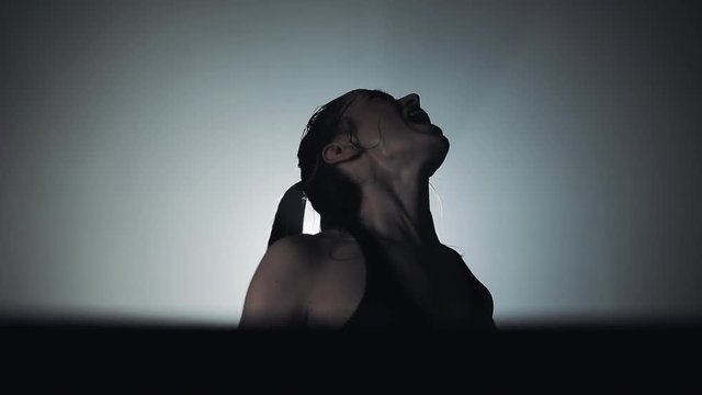 Young boxer girl with boxing gloves screams emotionally standing on the boxing ring. Slow motion