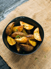 Country potato crispy on a dark wooden table . Fast food French fries