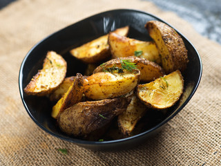 Country potato crispy on a dark wooden table . Fast food French fries