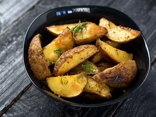 Country potato crispy on a dark wooden table . Fast food French fries