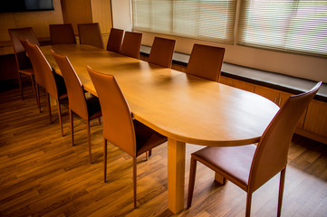 Modern wooden long table and leather chairs in the meeting room
