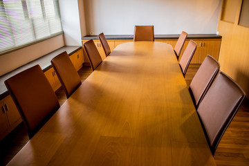 Modern wooden long table and leather chairs in the meeting room