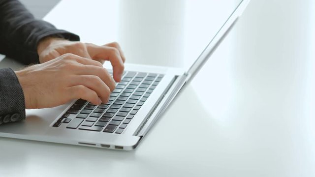 Product reviews. Online remote job. Freelance reviewer. Man hands typing on the laptop keyboard.