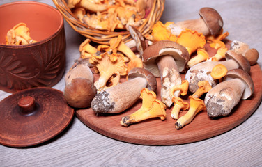 Boletus and chanterelles mushrooms in a basket on a wooden table