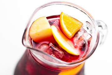 Refreshing summer red wine sangria drink in a glass pitcher close up, soft focus