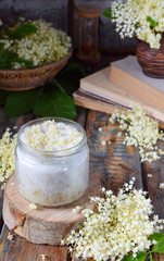 Elderflower sugar and blossom flower in wooden background. Edible elderberry flowers add flavour...