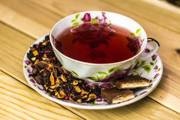 cup of herbal tea with spices on a light wooden background