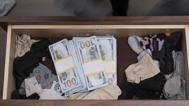 burglar rummages through a closet, discarding things and finding a lot of money. top view.